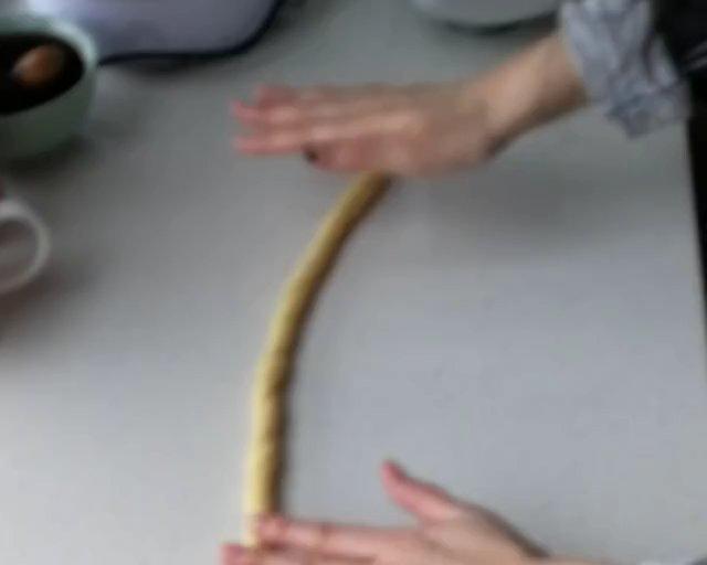 往下搓,拿起来对折,对折后再像刚才那么搓,再对折,把尾巴塞进上面的面